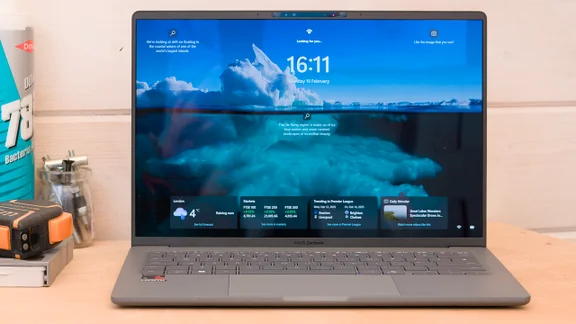 The Asus Zenbook A14 pictured from the front on a wood workbench