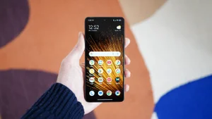 Xiaomi Poco X7 Pro in hand, in front of a multi-coloured rug, display showing the homescreen