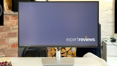 The Dell UltraSharp U2724DE pictured from the front, showing a Windows desktop with the Expert Reviews logo in the bottom right corner