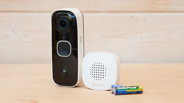 The SwanBuddy4K video doorbell pictured with its bundled chime and AA batteries