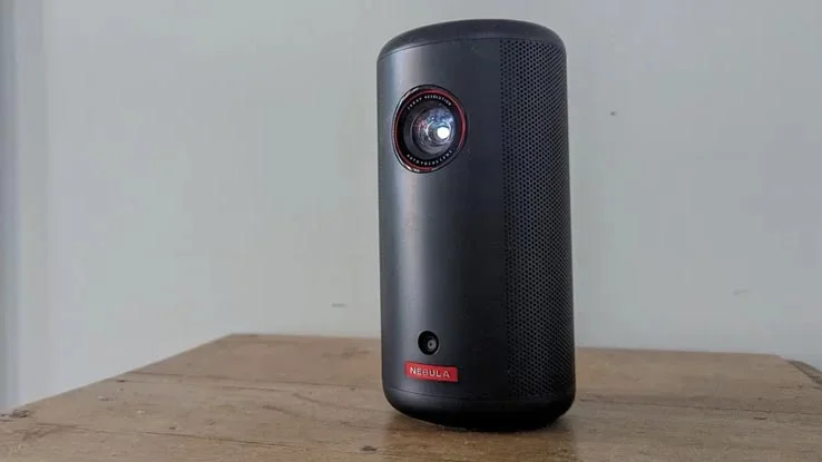 The Nebula Capsule 3 projector on a wooden table