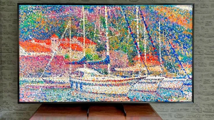 The Samsung QN900F 8K TV on a wooden table displaying digital artwork