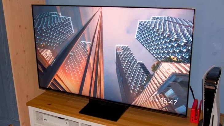 The TCL C7K QD-Mini LED TV on a TV cabinet alongside a Nintendo Switch and PlayStation 5