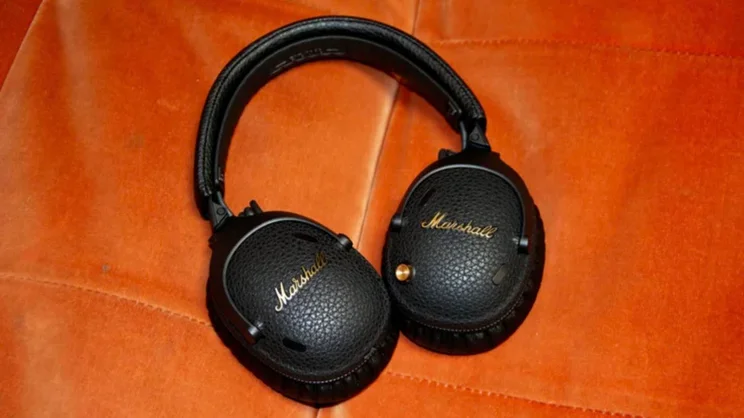 The Marshall Monitor III ANC over-ear headphones on an orange sofa