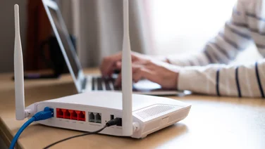 woman working on a laptop next to a wireless router