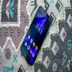 Google Pixel 9a on a patterned cushion, face up