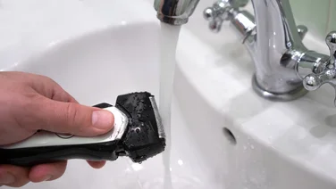 How to clean an electric shaver razor being cleaned under the tap