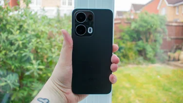 Oppo Reno 13 Pro in hand in front of a window, rear view