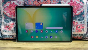Samsung Galaxy Tab S10 FE Plus in front of a patterned cushion, display on