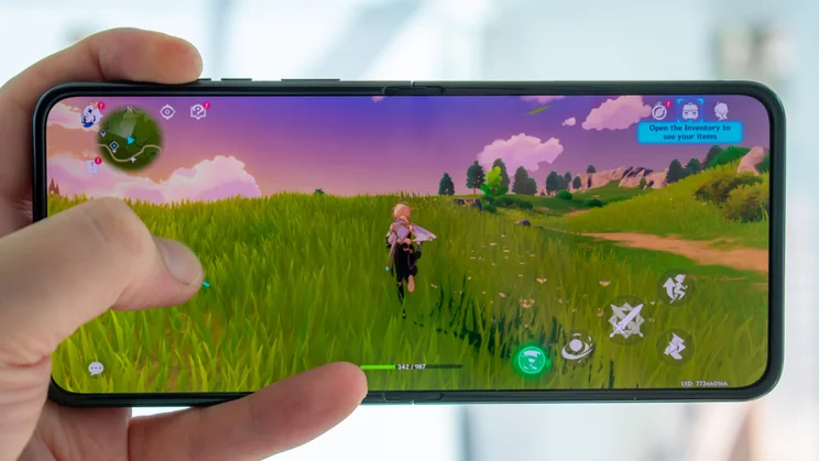 Motorola Razr 60 Ultra unfolded in hand, playing a mobile game on the display