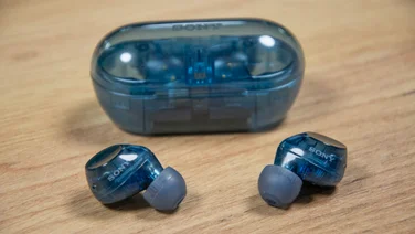 The Glass Blue Sony WF-C710N wireless earbuds outside of their charging case on a wooden table