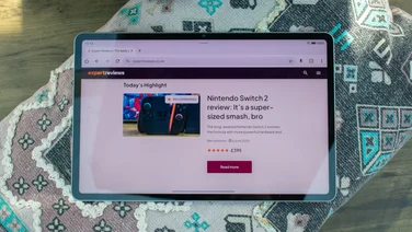 Honor Pad 10 tablet on a patterned cushion, showing the Expert Reviews homepage on its display