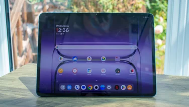 OnePlus Pad 3 sitting upright on a desk with the display showing the homepage