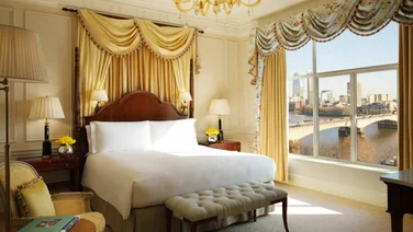 Savoy bedroom with white bedding and gold swag fabric details