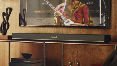 The Marshall Heston 120 soundbar displayed under a TV mounted on a 1970s style shelf unit
