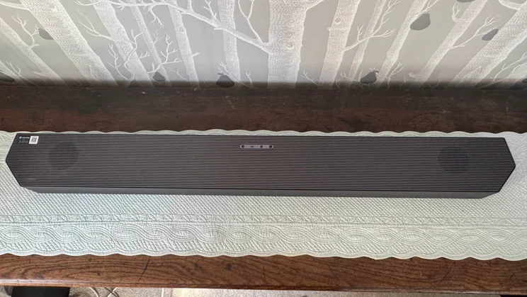 Top-down view of the soundbar component of the Samsung HW-Q990F home audio system on a wooden dresser