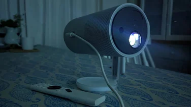 The XGIMI MoGo 4 portable projector on a table projecting an image in a dark room