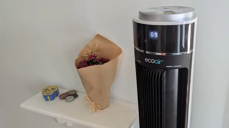 The upper half of the EcoAir Halo tower fan, next to a shelf in a home