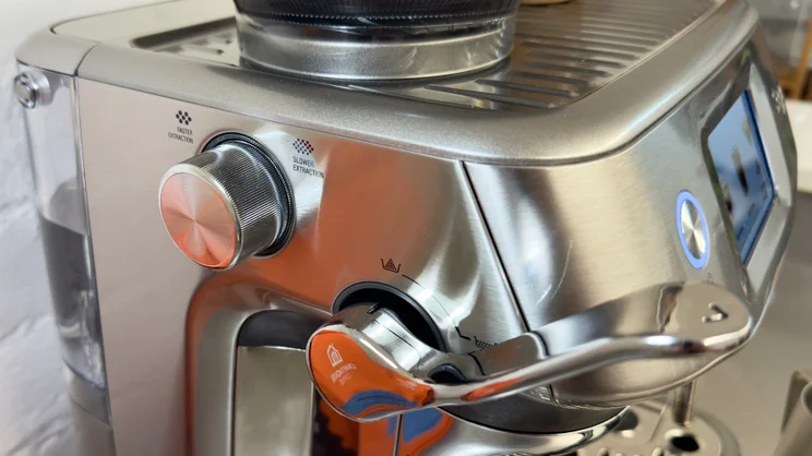The Sage Barista Touch Impress' tamping lever and grind size adjustment knob