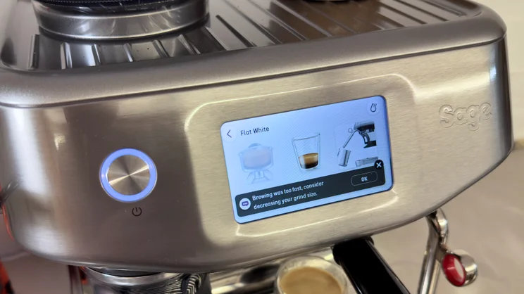 A close up of the Sage Barista Touch Impress' touchscreen display showing advice to reduce grind size