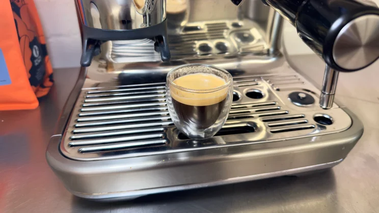 A cup of espresso, on the drip tray of the Sage Barista Touch Impress