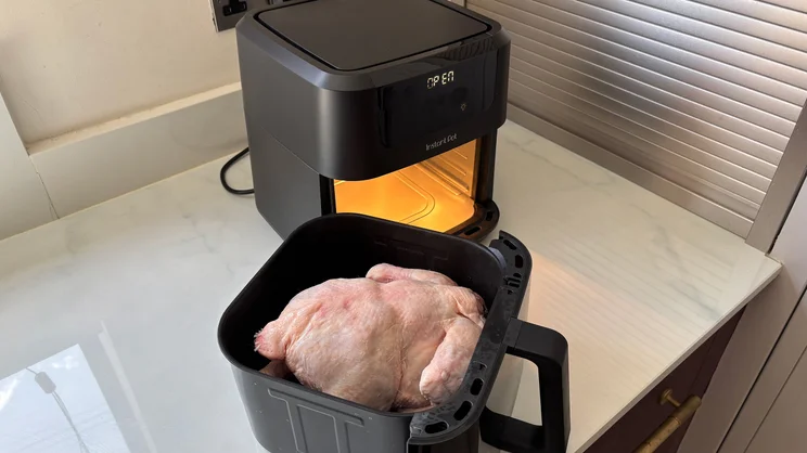 An uncooked chicken inside the drawer of the Instant Pot Vortex Compact 5L air fryer