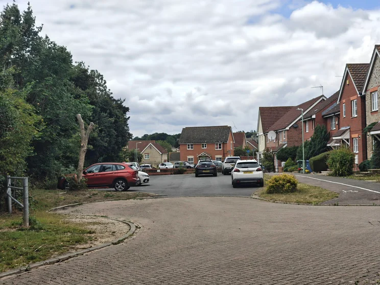 2x zoom of a close of houses with cars parked out front