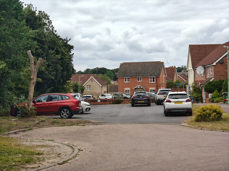 3x zoom of a close of houses with cars parked out front