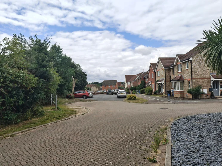 A quiet close of houses with cars parked out front
