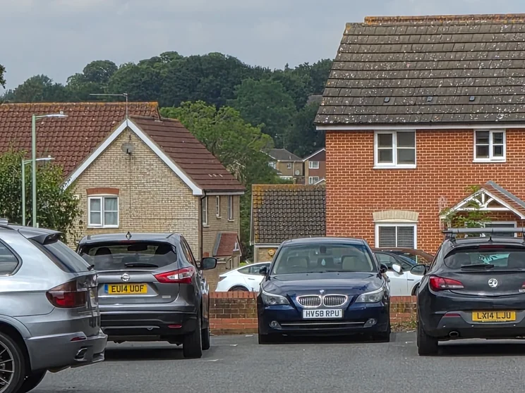 10x zoom of houses with cars parked out front