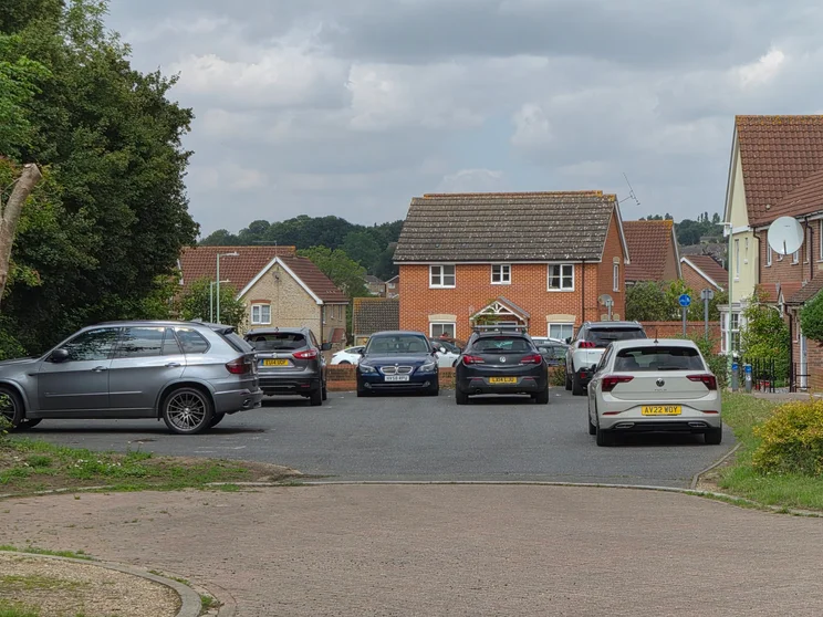 4x zoom of houses with cars parked out front