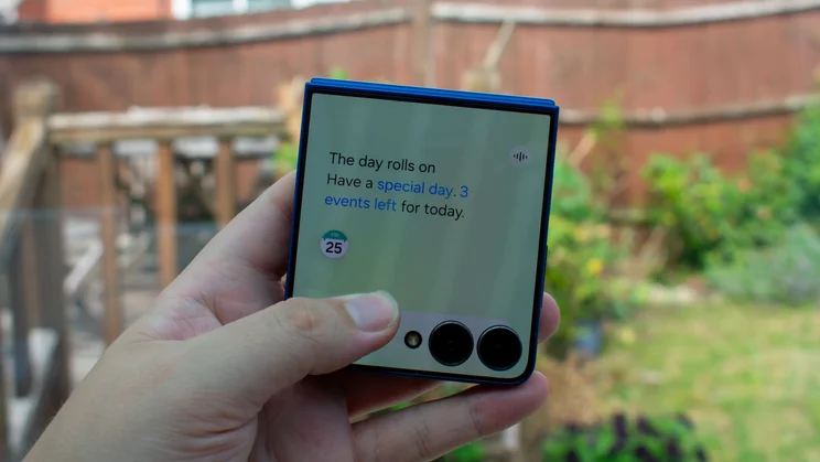 Samsung Galaxy Z Flip 7 folded in hand, showing the Now Brief on the cover display