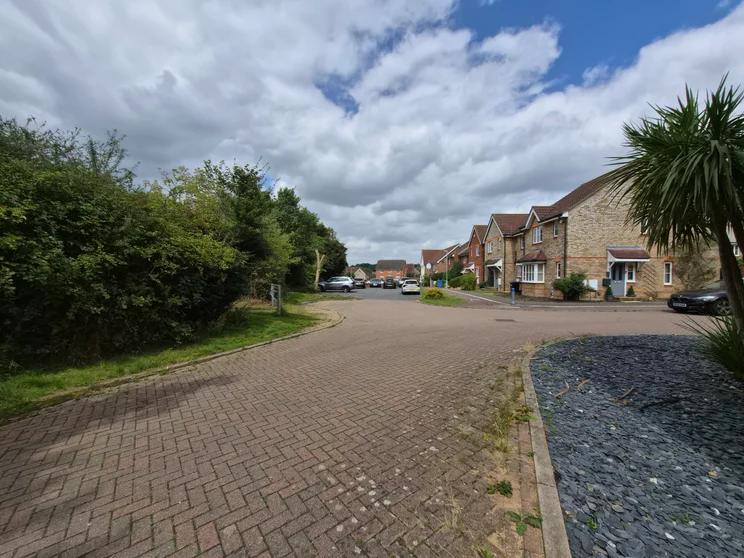 Wide angle shot of houses with cars parked out front
