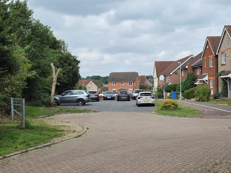 2x zoom of houses with cars parked out front