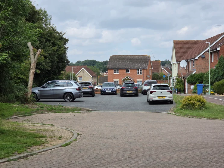 3x zoom of houses with cars parked out front