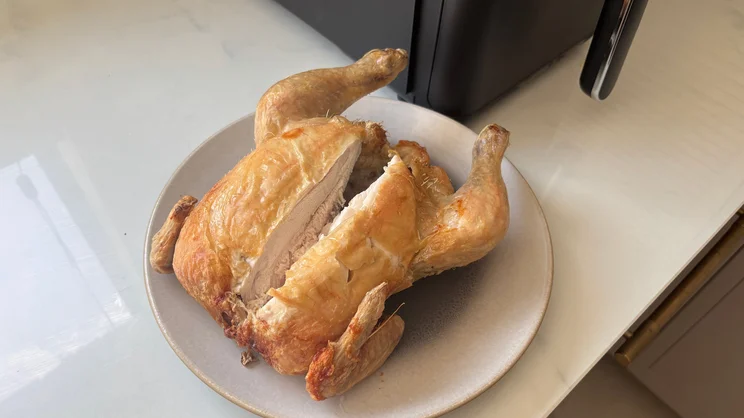 A cooked chicken cut in half, on a plate