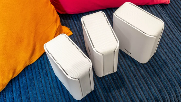 Top-down view of the Asus ZenWiFi BD4 mesh system on a blue sofa
