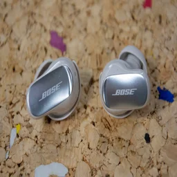 The Bose QuietComfort Ultra Earbuds 2nd Gen on a cork table