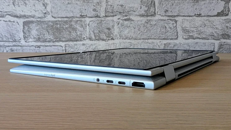 The HP EliteBook X Flip G1i in tablet configuration lying on a wooden desk