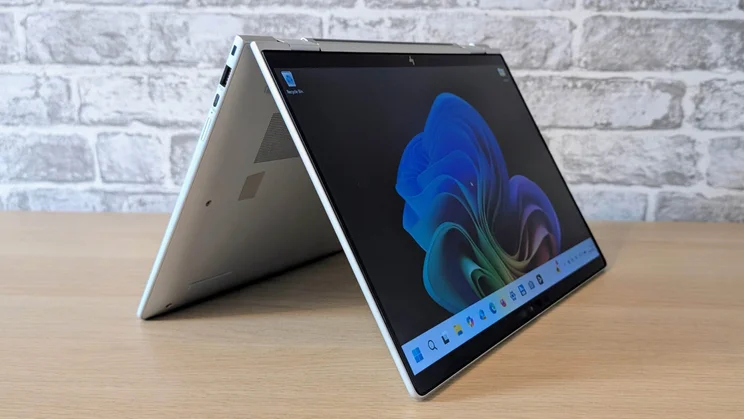 The HP EliteBook X Flip G1i in tent configuration on a wooden desk