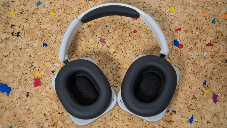 The Nothing Headphone (1) lying flat on a cork table with their earcups facing upwards