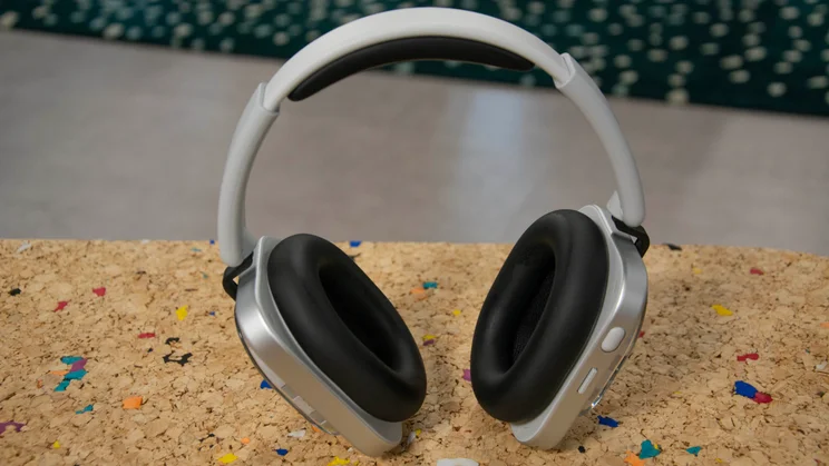 The Nothing Headphone (1) stood up vertically on a cork table