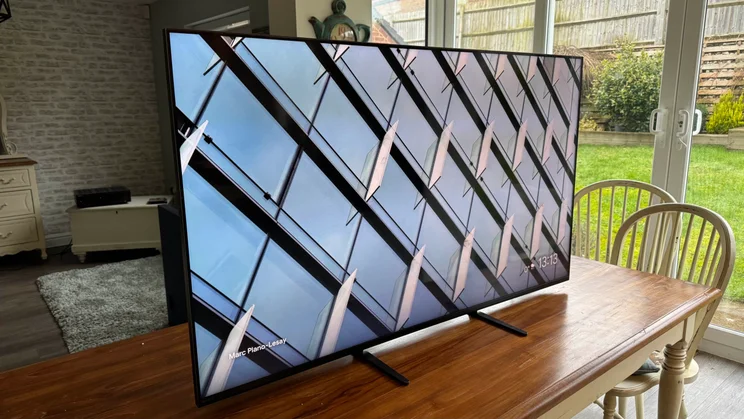 The Sony Bravia 9 Mini LED TV on a wooden table in a kitchen with patios doors looking out towards a garden