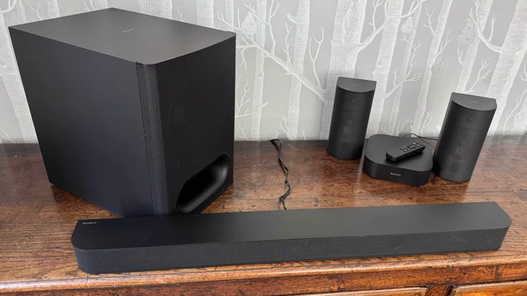 The soundbar, subwoofer, rear speakers and Wi-Fi receiver of the Sony Bravia Theatre System 6 on a wooden table