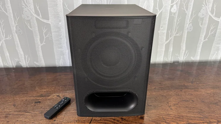 Front view of the subwoofer component of the Sony Bravia Theatre System 6 and the accompanying remote control
