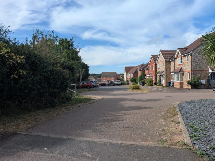 A quiet close of houses with cars parked out front