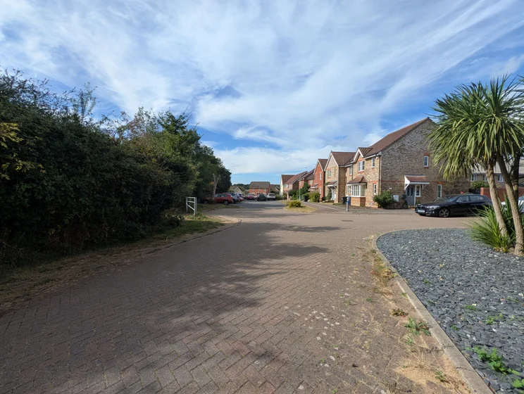 Wide-angle view of a close of houses with cars parked out front