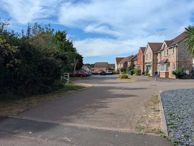 A quiet close of houses with cars parked out front