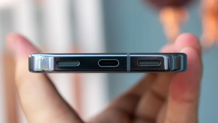 Google Pixel 10 Pro in hand, showing the bottom edge and charging port