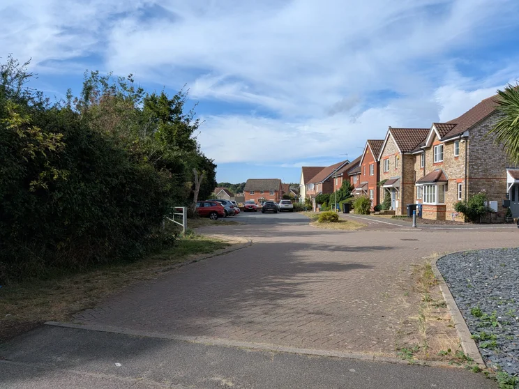 A close of houses with cars parked in front
